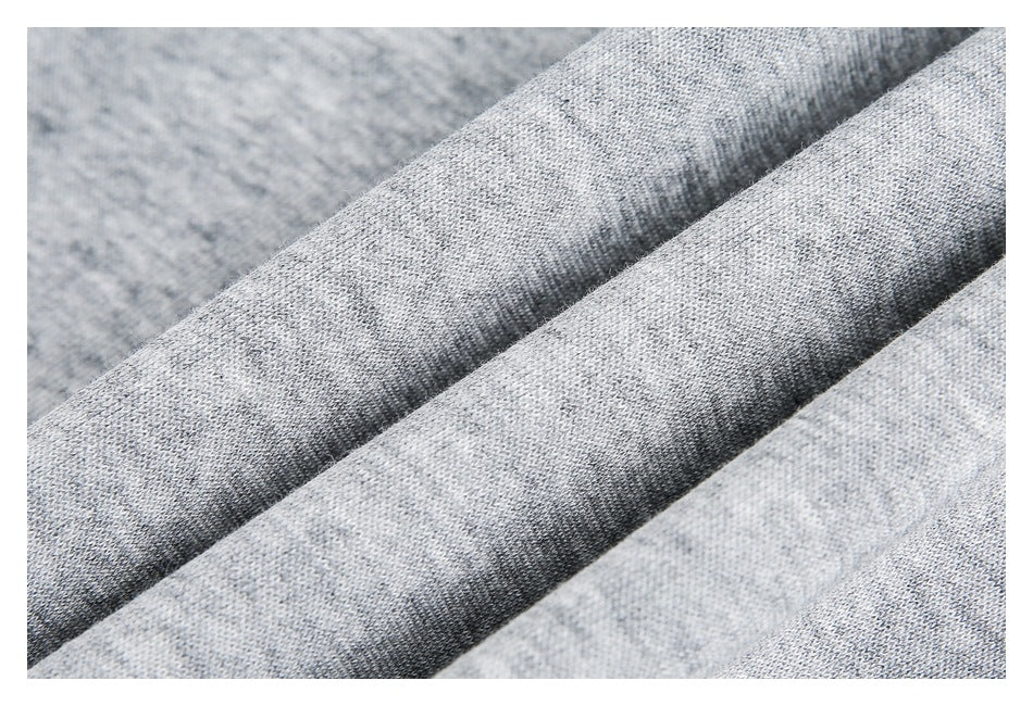 Close-up of folds showing the texture of light gray marled knit fabric.