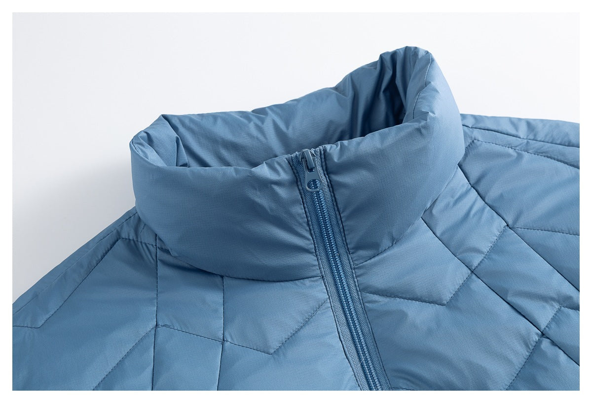 Close-up of the blue jacket's high padded collar and front zipper, with geometric quilted stitching at the shoulders.