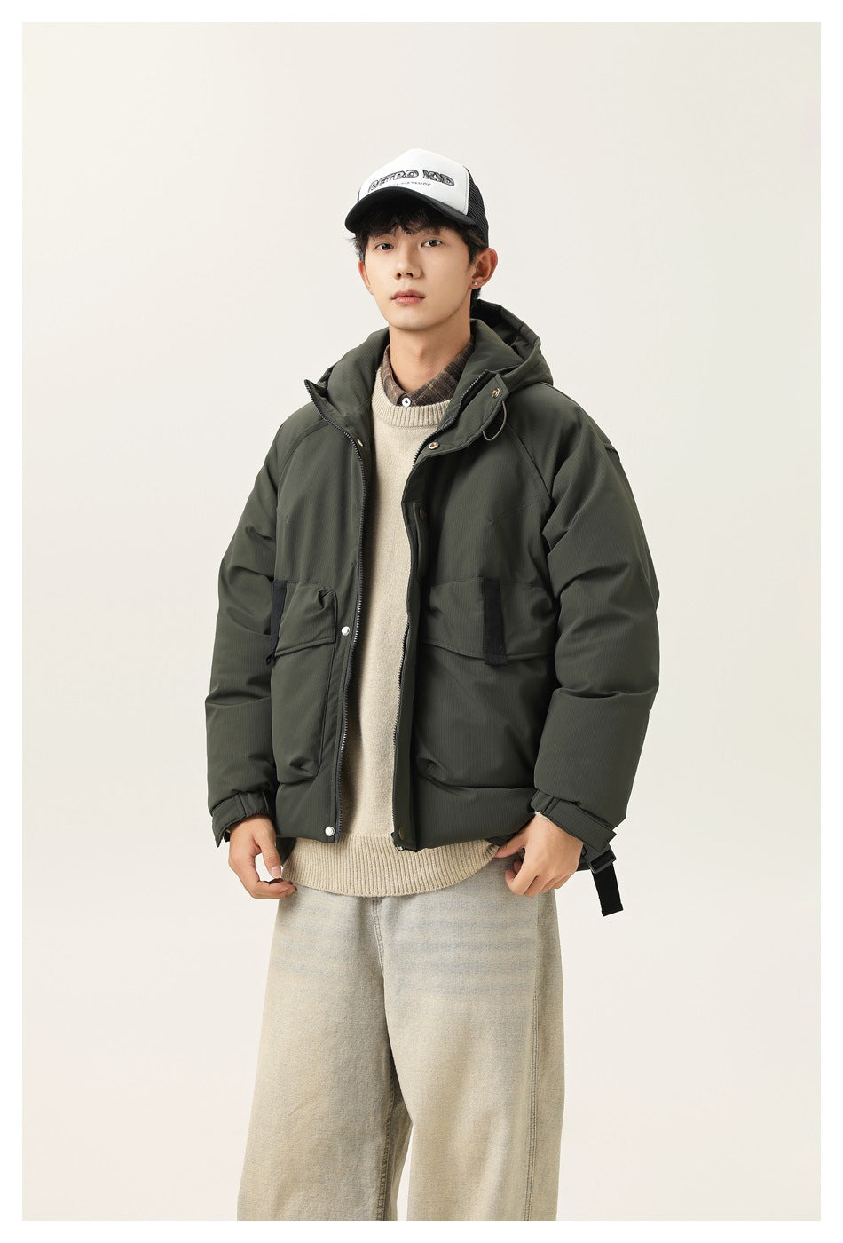 Front view of a model in a dark olive hooded jacket with a zip front, snap closures, and large flap pockets.