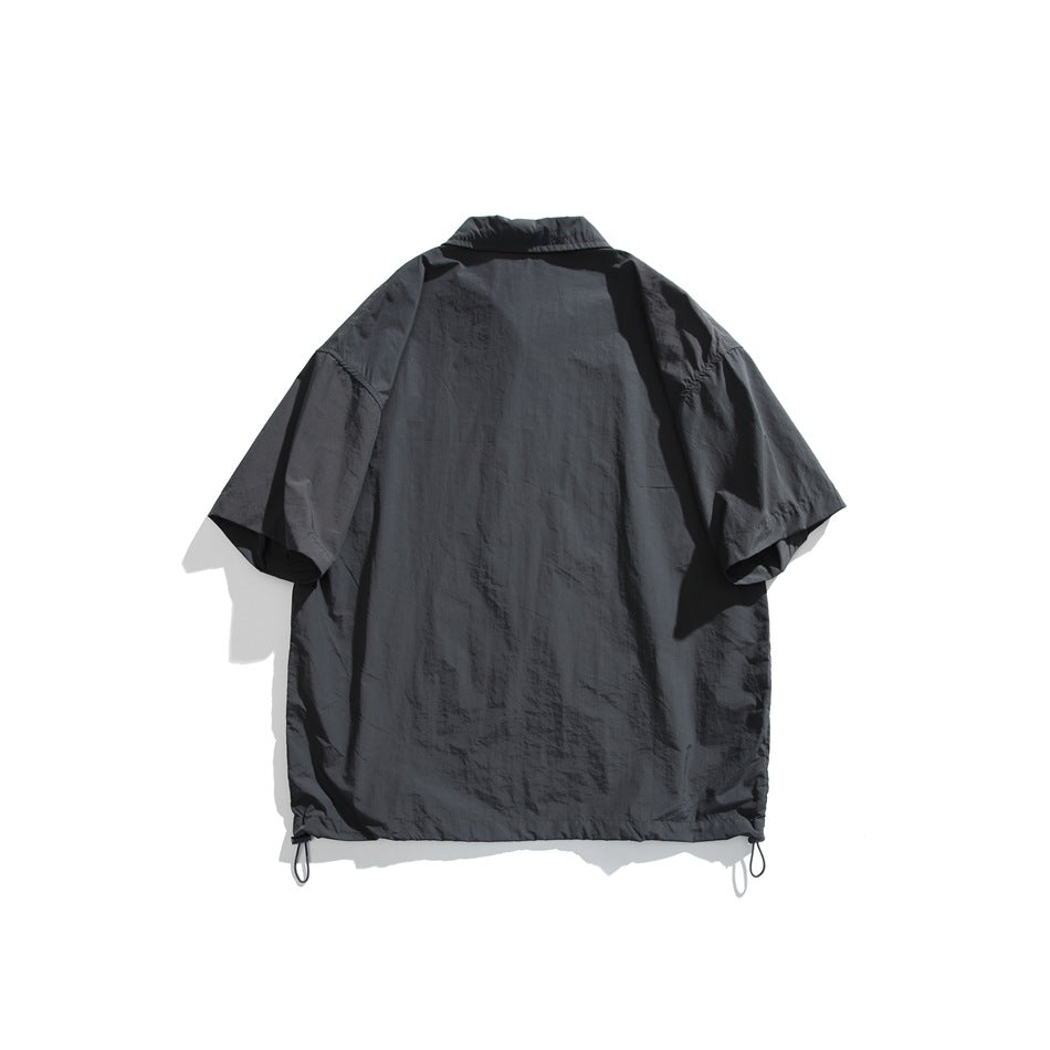 Back view of dark gray short-sleeve shirt with crinkled fabric and drawcord hem toggles, flat lay