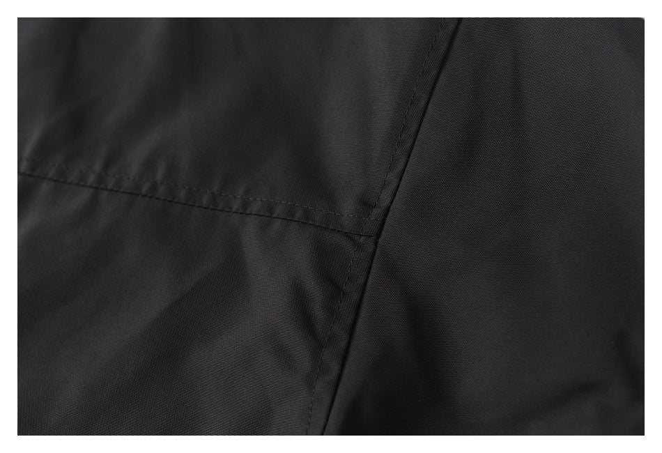 Close-up of black jacket fabric with intersecting stitched seams.