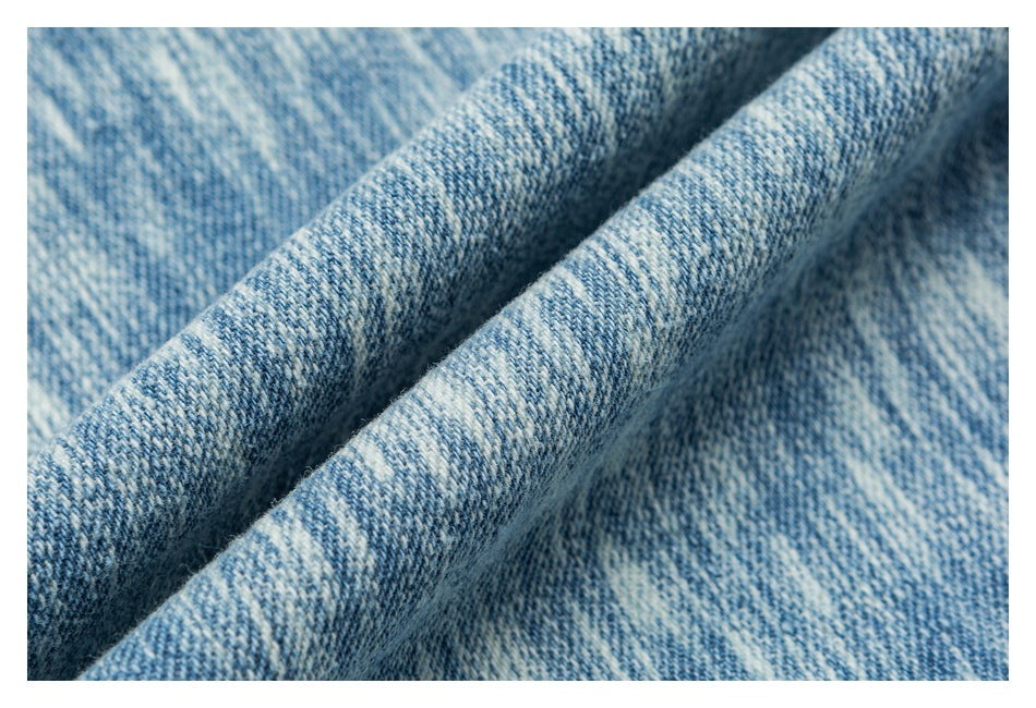Macro view of the mottled blue-and-white denim surface and its diagonal weave.