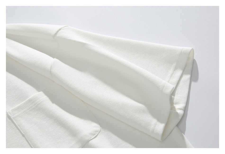Close-up of the white top's long sleeve and stitched cuff.