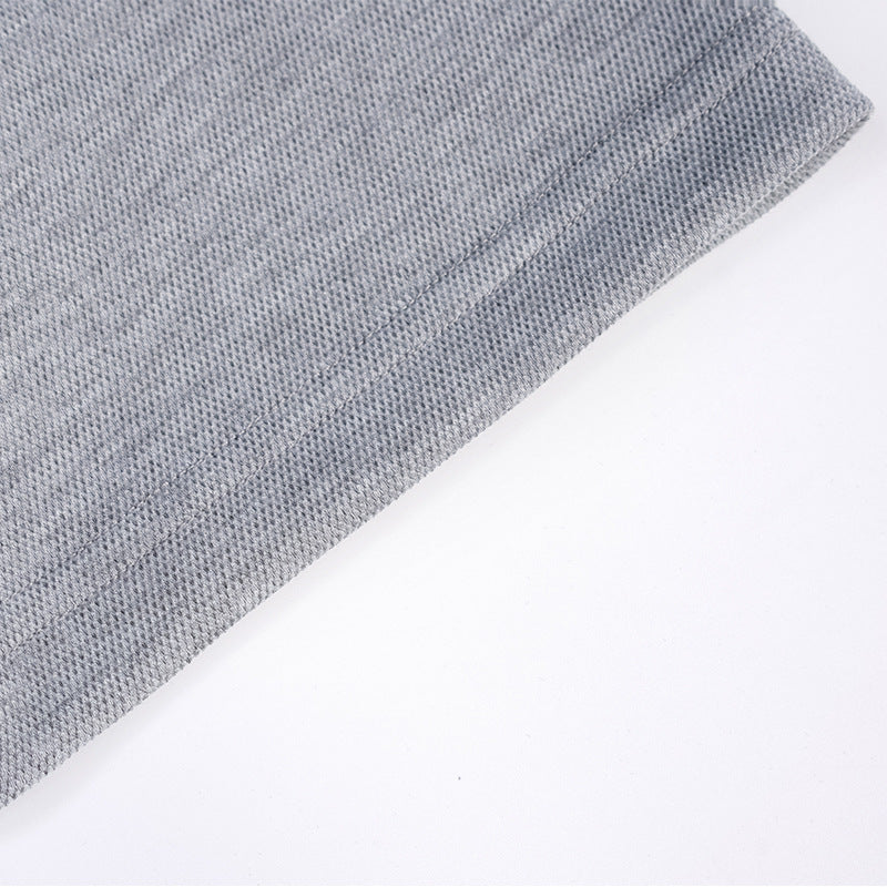 Close-up of the textured heather gray fabric and stitched sleeve hem against a white background.