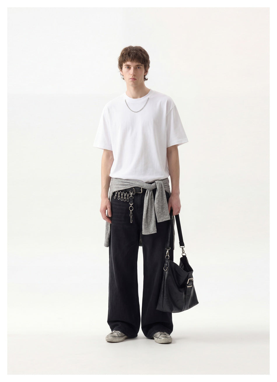Full-length front view of a model wearing a plain white crew-neck T-shirt and loose black trousers.