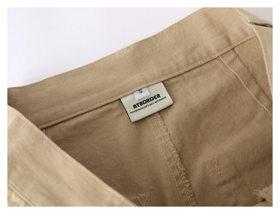 Inside waistband detail of beige pants with a sewn-in size label marked S and AT BORDER.