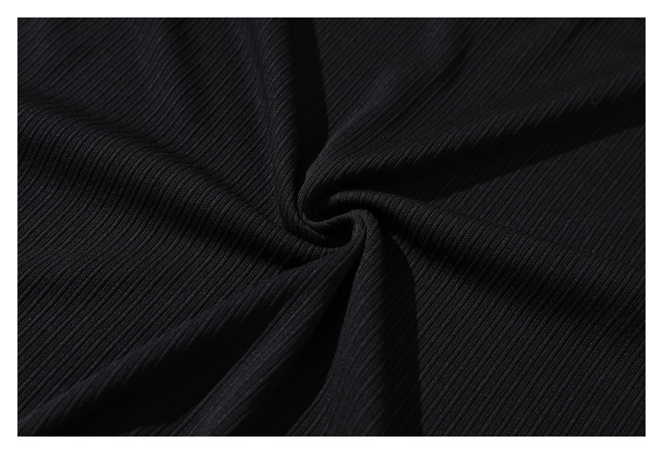 Close-up of black ribbed fabric gathered into soft folds.