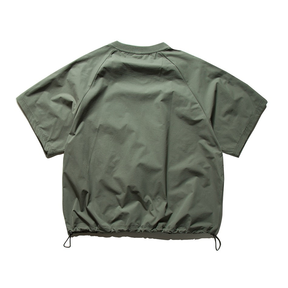 Back view of a muted-green short-sleeve top with raglan seams and drawcords at the hem.