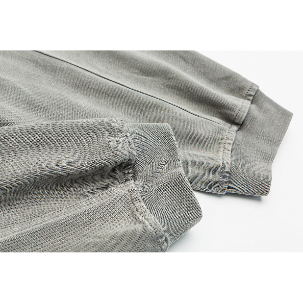 Close-up of the gray shirt’s long sleeve and ribbed cuff, showing the stitching and fabric texture.
