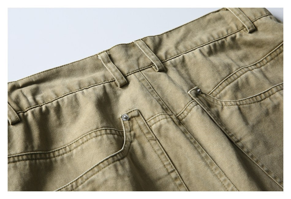 Close-up of the khaki trousers' front waistband, belt loops, button, fly, and pockets.