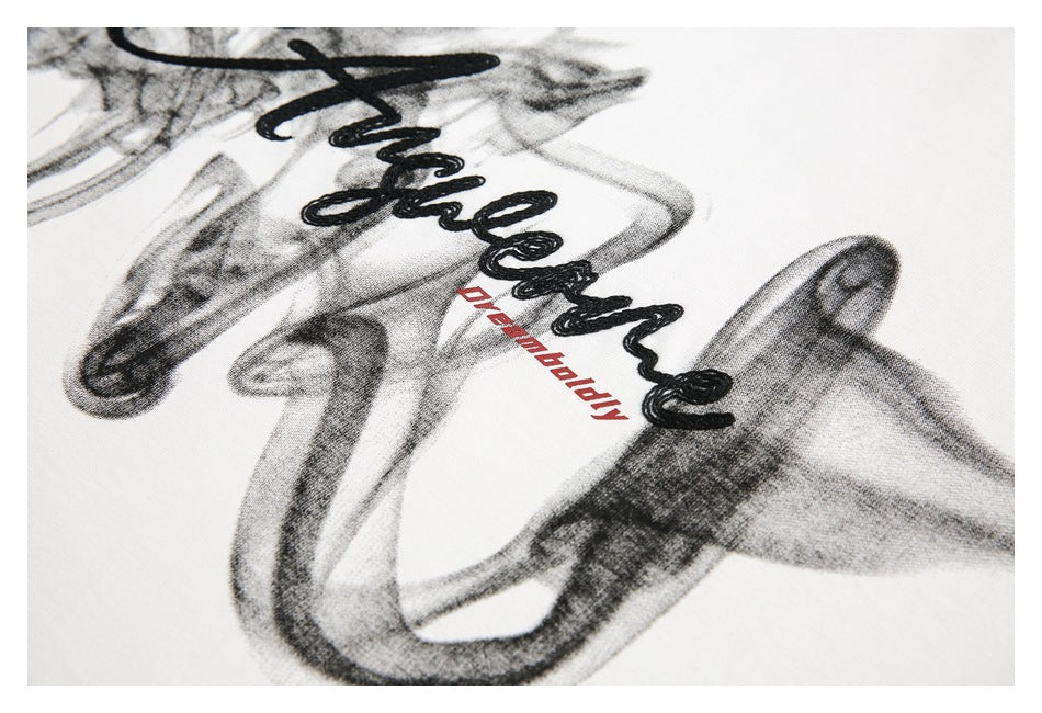 Angled close-up of the black cursive and red lettering printed on white fabric.