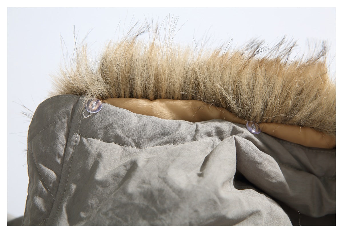 Close-up of a gray jacket hood edged with tan faux fur and secured with clear buttons.