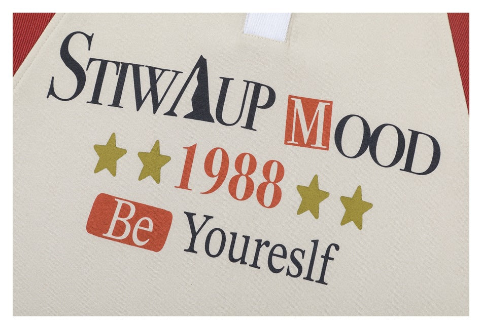Close-up of a beige garment printed with black and rust lettering, olive stars, and the year 1988.