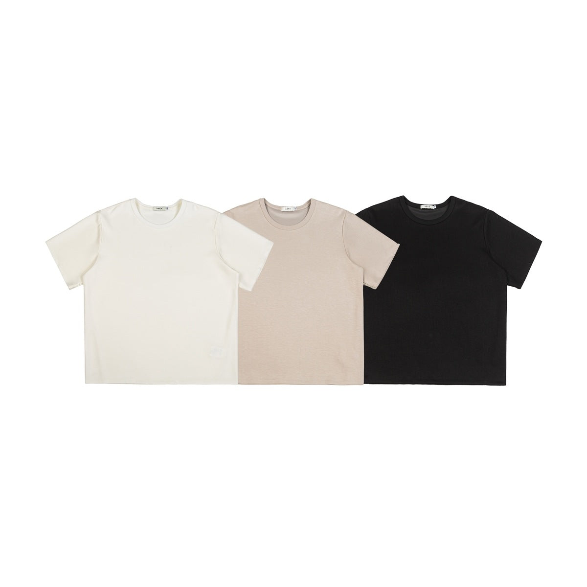 Three plain short-sleeve crew-neck T-shirts shown from the front in white, beige, and black.