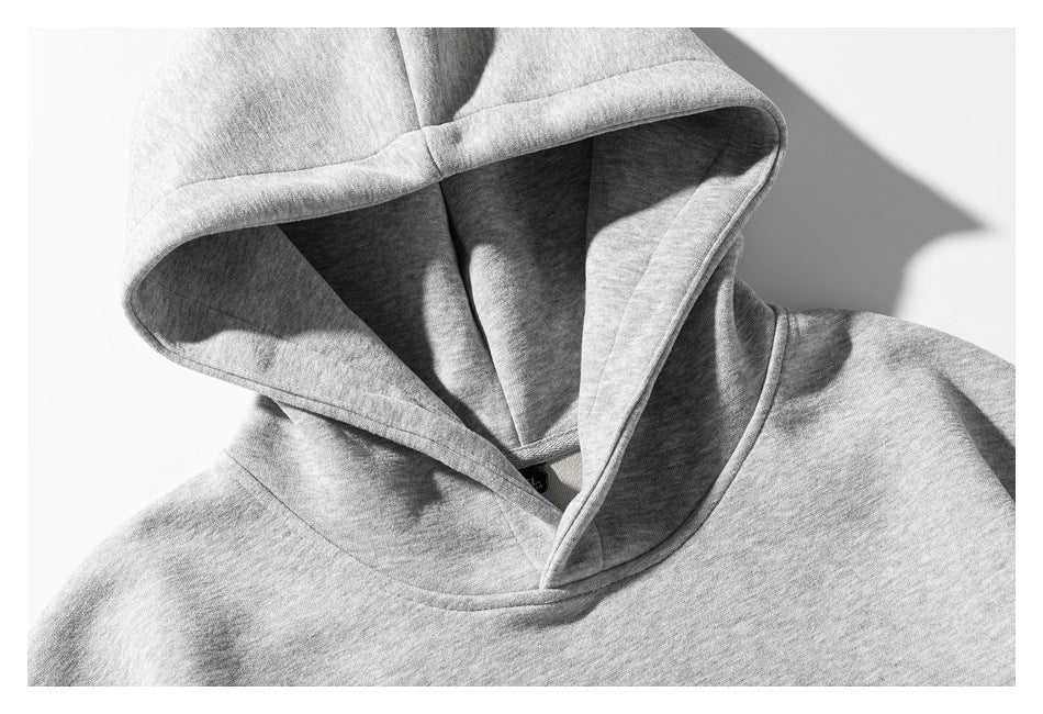 Close-up of the light gray sweatshirt's hood, showing its lining, seams, and neckline.