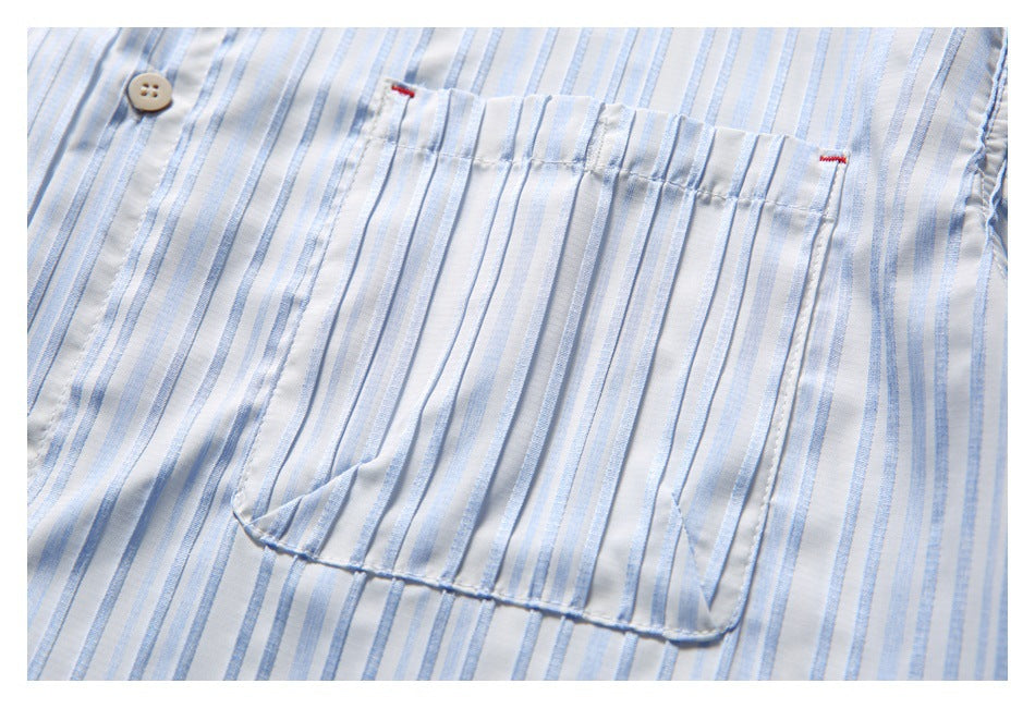 Close-up of a large patch pocket on a white shirt with pale blue stripes and small red stitch accents.