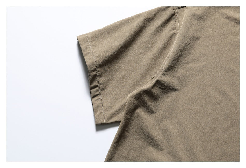Close-up of the taupe top's short sleeve and curved underarm seam.