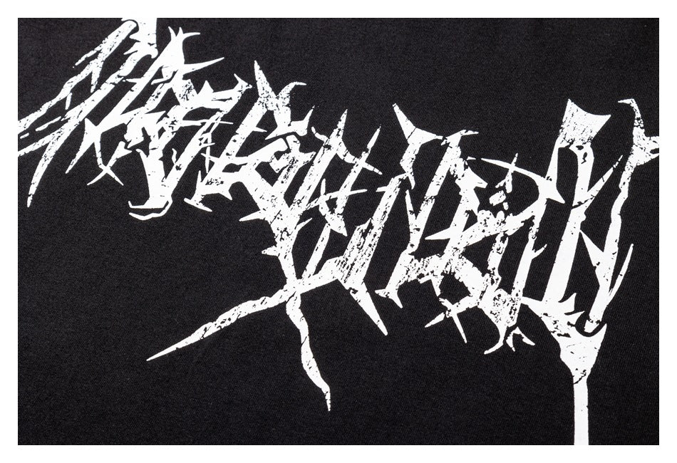 Close-up of a black garment with a large distressed white abstract lettering print.