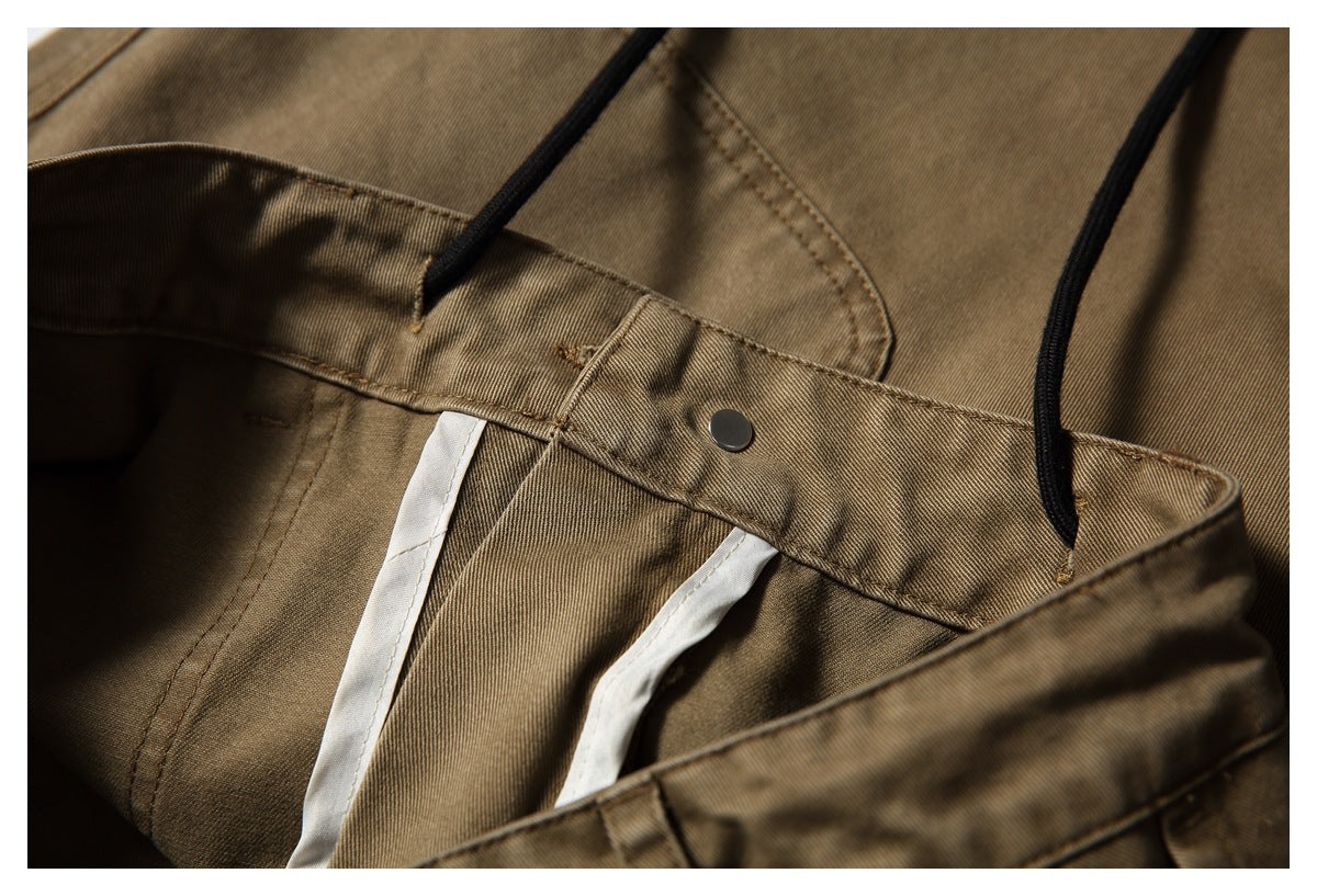 Inside waistband detail of tan-brown trousers, showing the button, seams and pale inner facing.