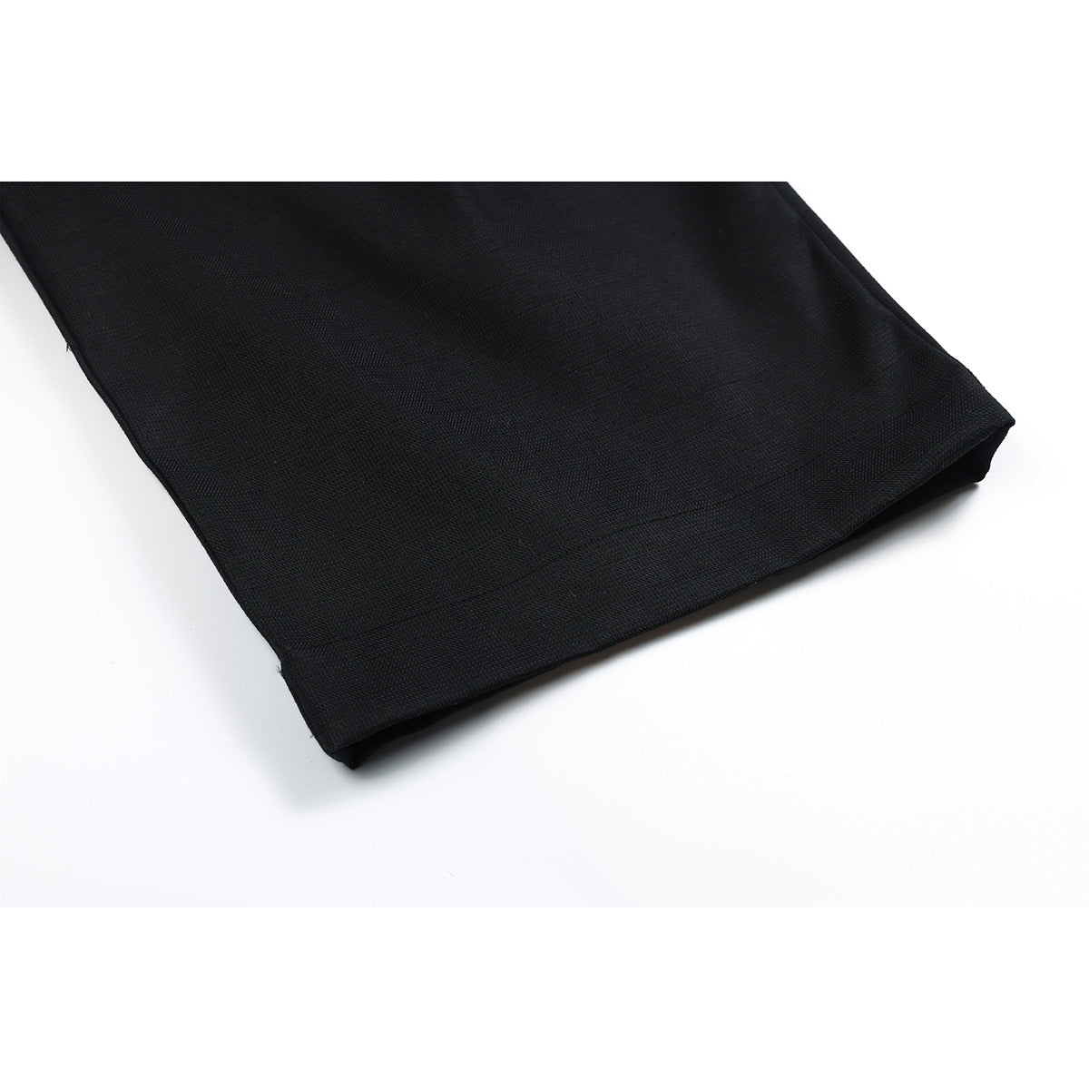 Close-up of the wide hem on a black trouser leg.