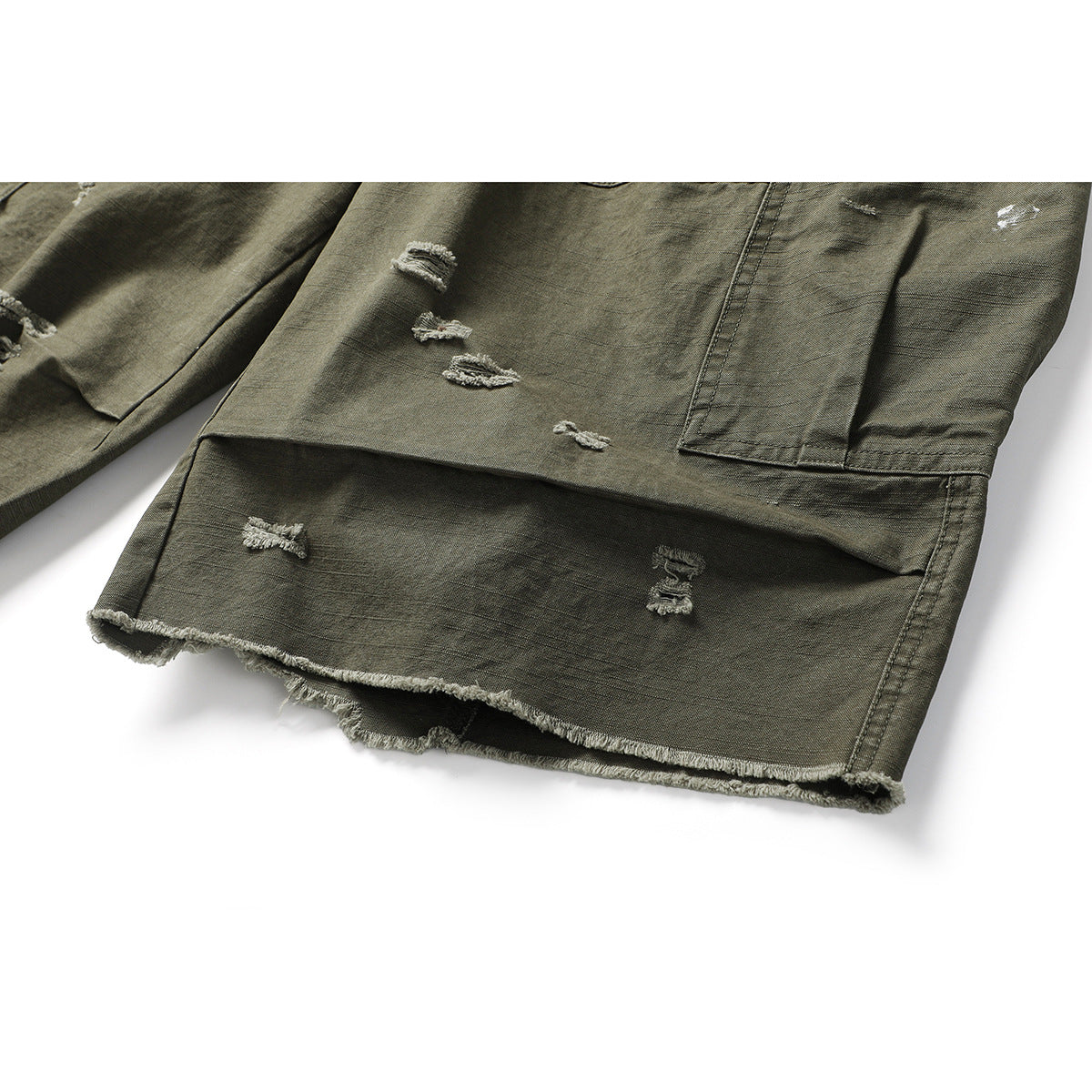 Close-up of olive cargo shorts showing distressed patches and a raw, frayed hem.