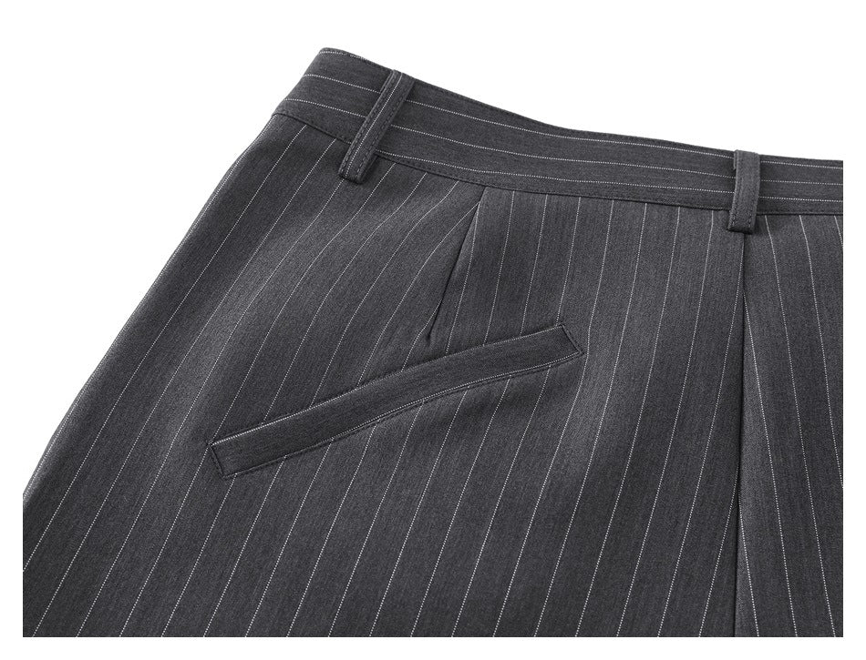 Close-up of the front waist and slanted pocket of charcoal pinstripe trousers, with belt loops and pleats.
