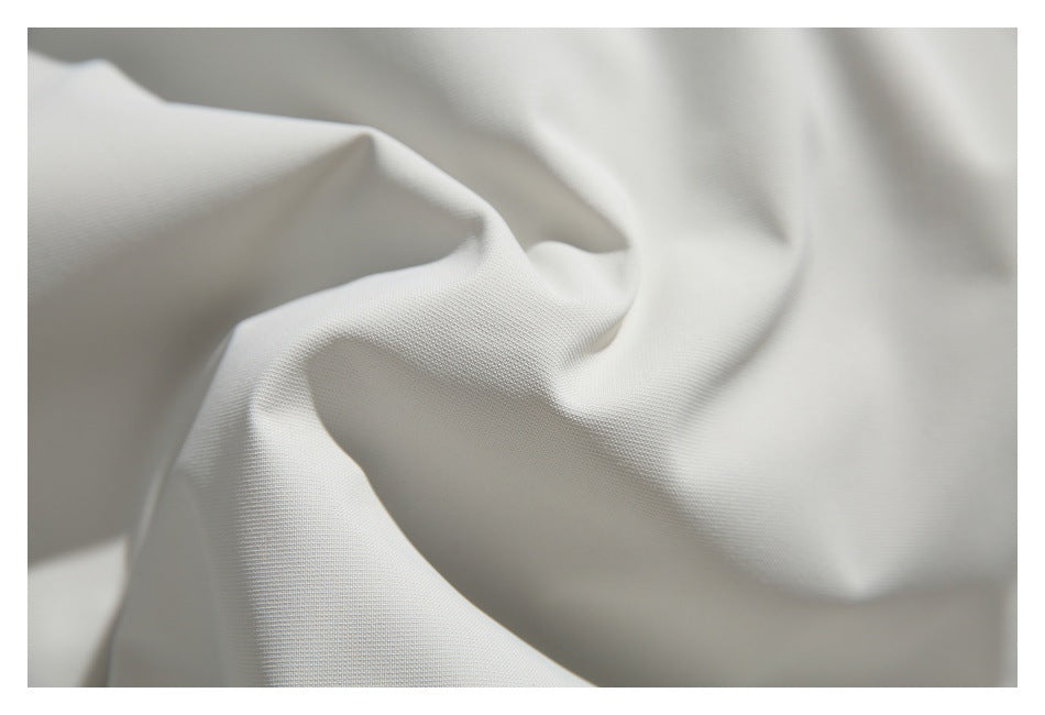 Close-up showing the fine texture and folds of white garment fabric.