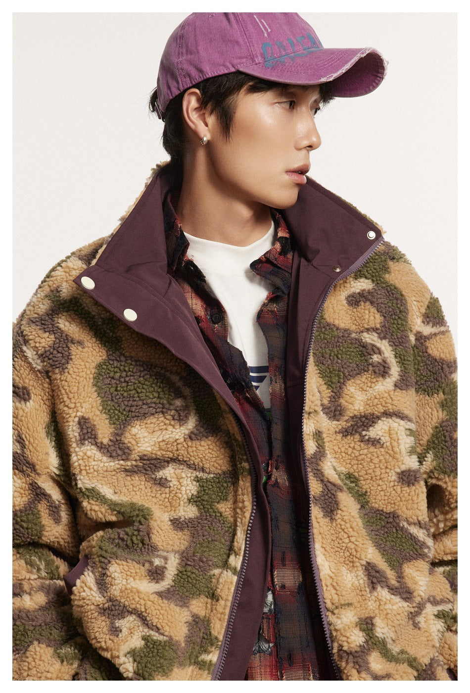 Close view of a model wearing a camouflage fleece jacket with a plum high collar, snap placket, and zipper.