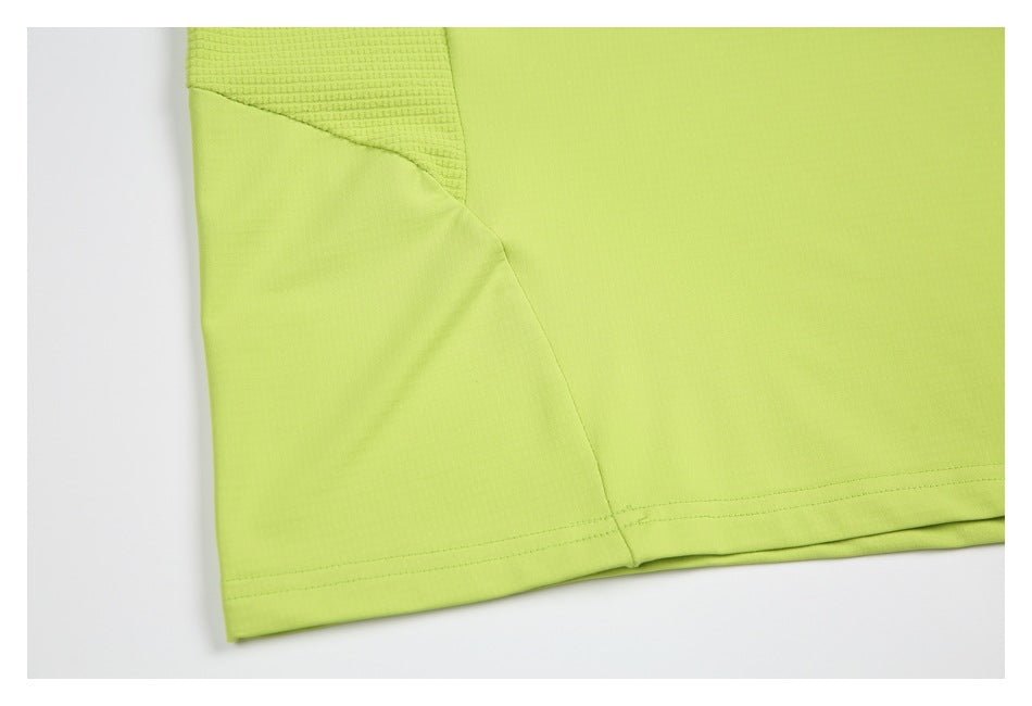 Close-up of a lime-green garment's textured inset, side seam, and stitched hem.