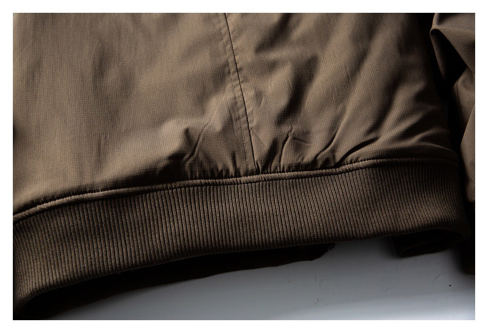 Close-up of a brown garment hem with a stitched seam and wide ribbed band.