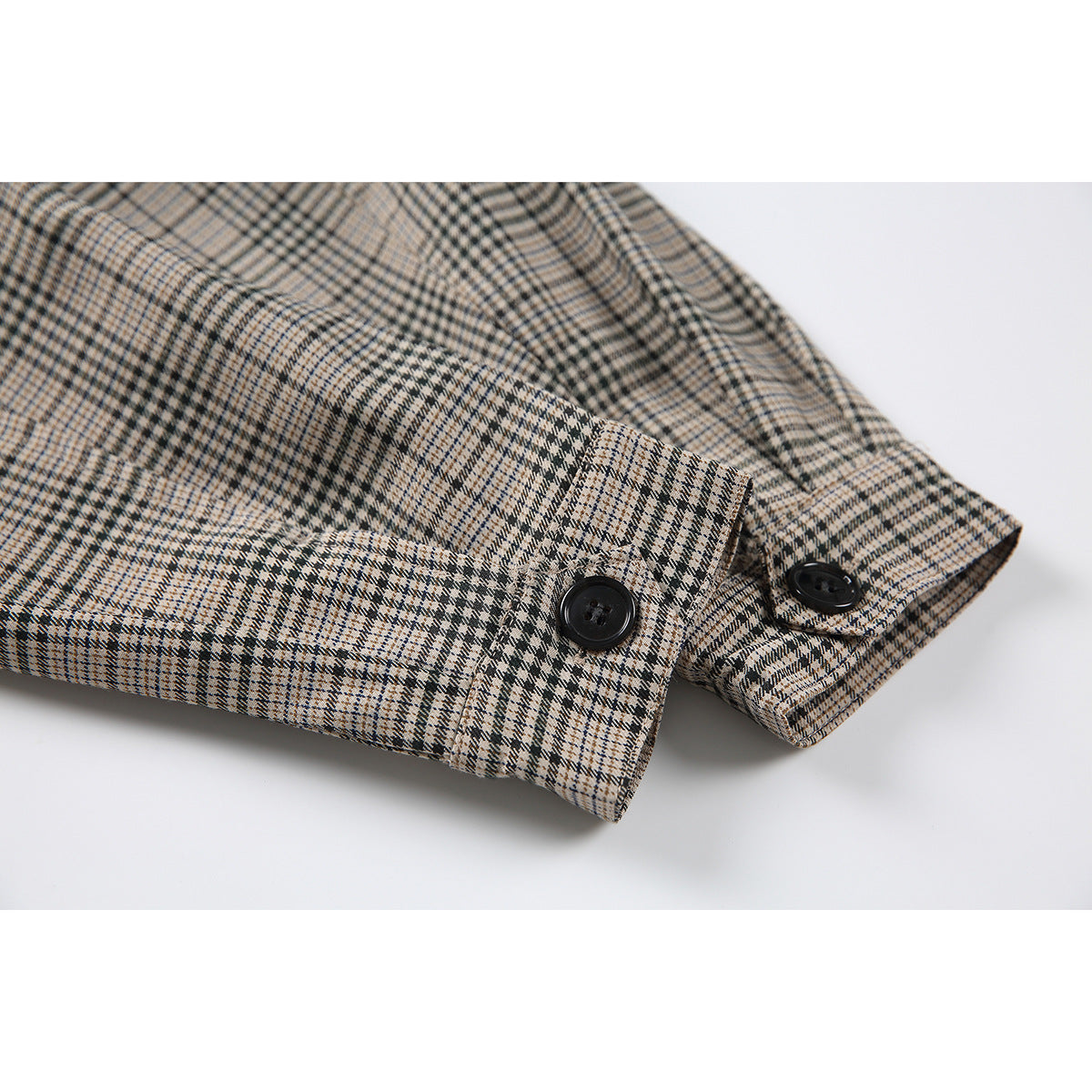Close-up of the plaid sleeve cuff with two black buttons.