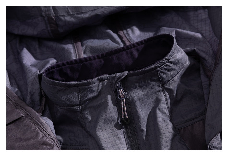 Close-up of the charcoal jacket's high collar, front zipper and patterned inner lining.