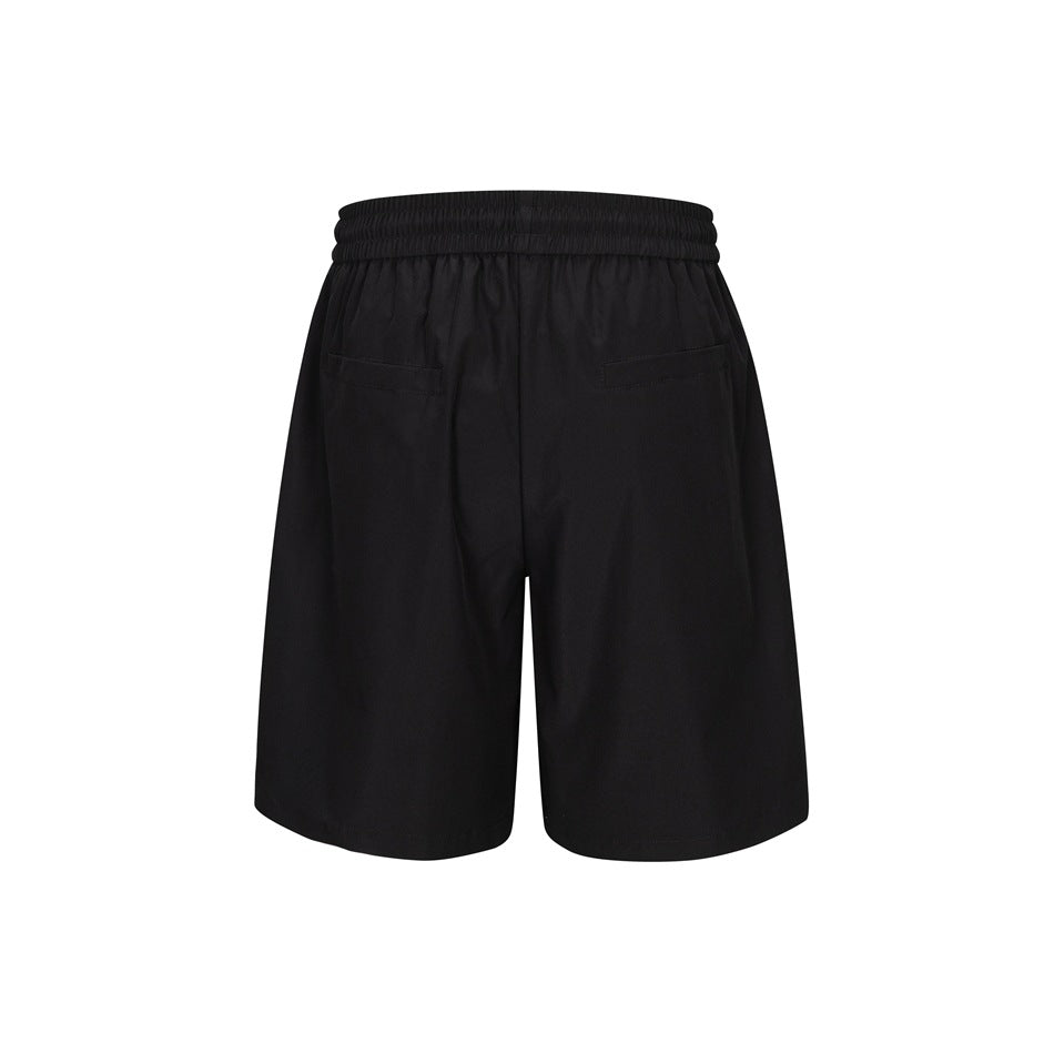 Back view of black loose shorts with an elastic waistband and two rear pockets.