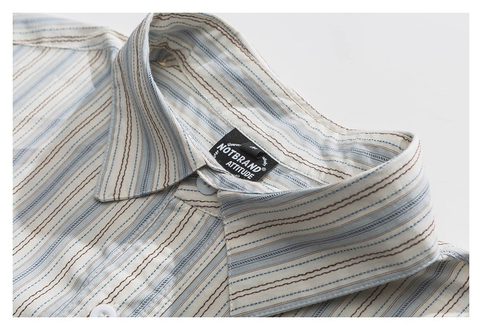 Close-up of a cream striped shirt collar and sewn-in neck label.