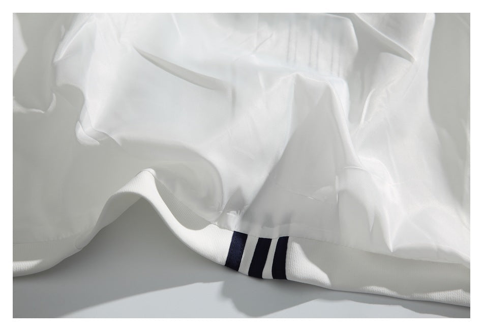 Close-up of a white garment hem with navy stripe trim.