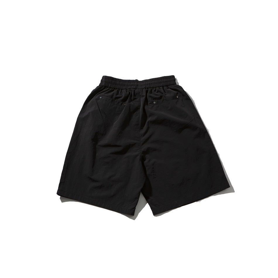 Back view of black shorts laid flat, showing an elastic waistband and rear pockets.