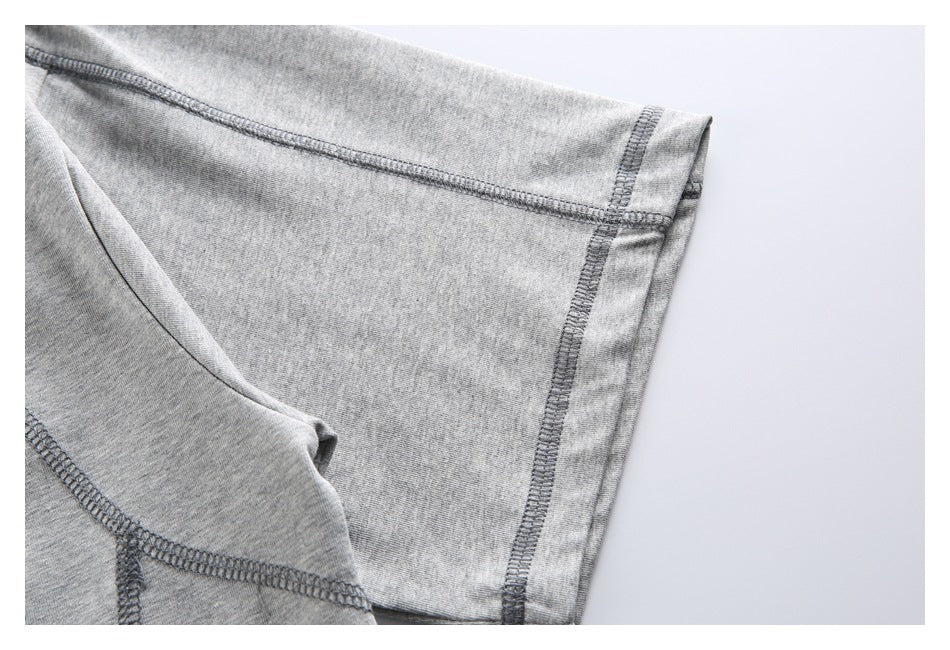 Close-up of the heather-gray shirt’s sleeve and overlocked seam stitching.