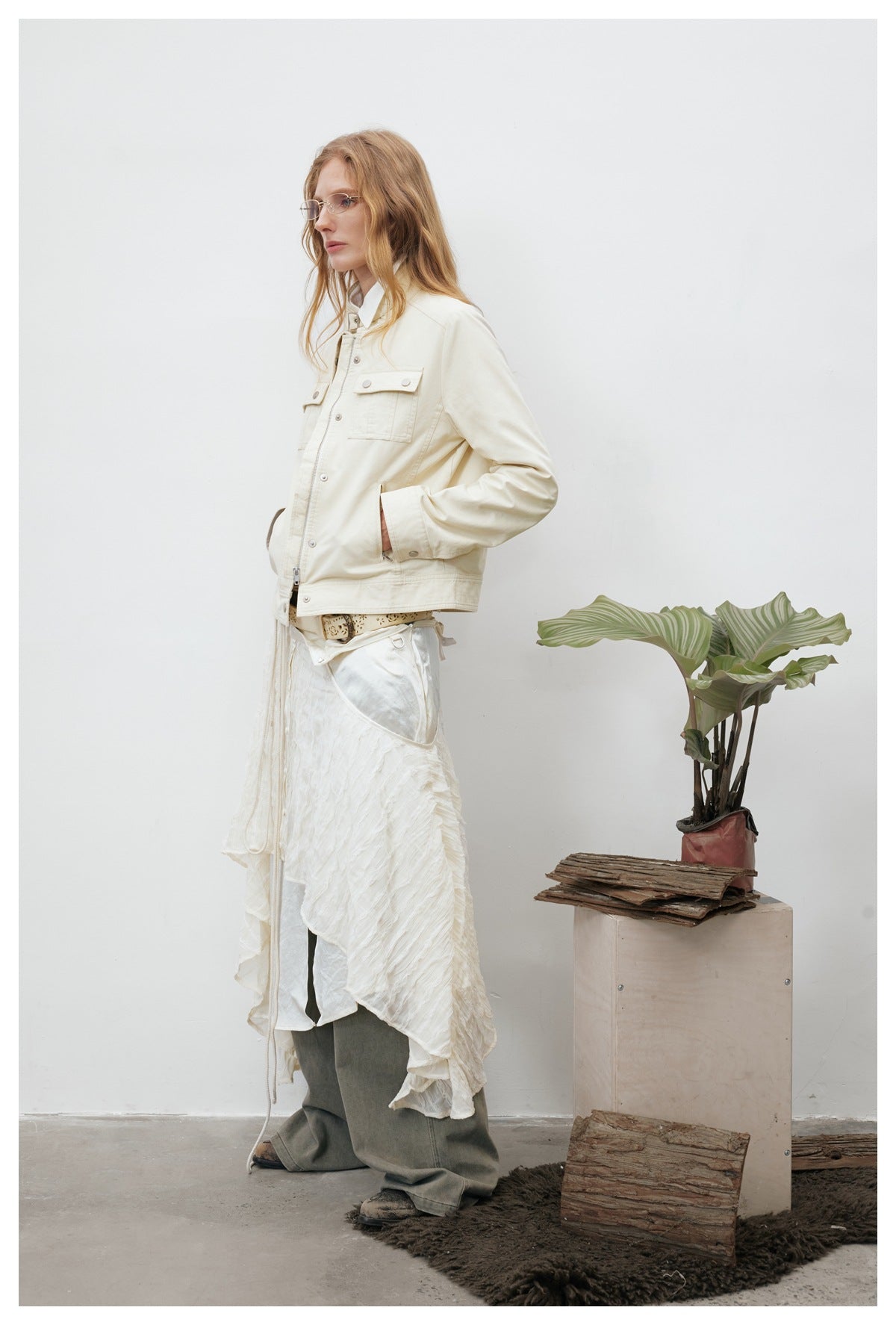 Side view of a model wearing an ivory utility jacket with chest pockets and a stand collar.