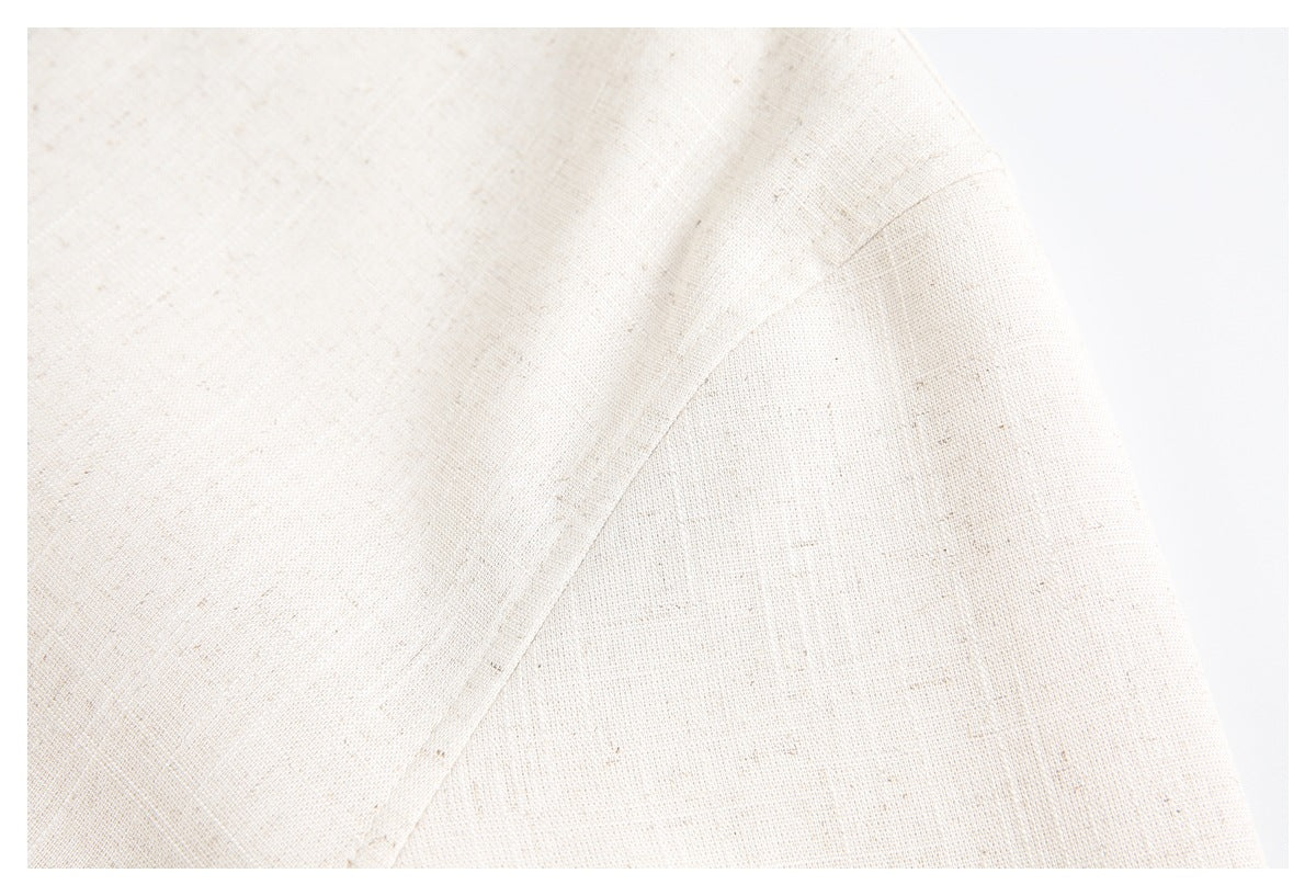 Close-up of the cream, subtly flecked jacket fabric and a curved stitched seam.