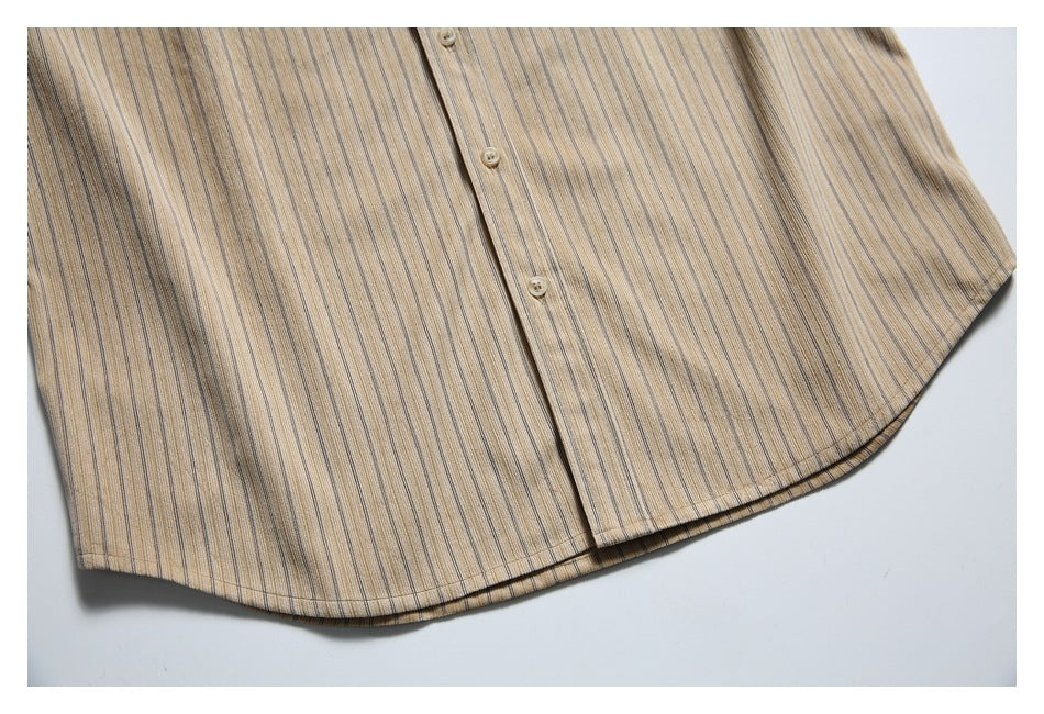 Close-up of the button placket and curved hem on a beige vertically striped shirt.