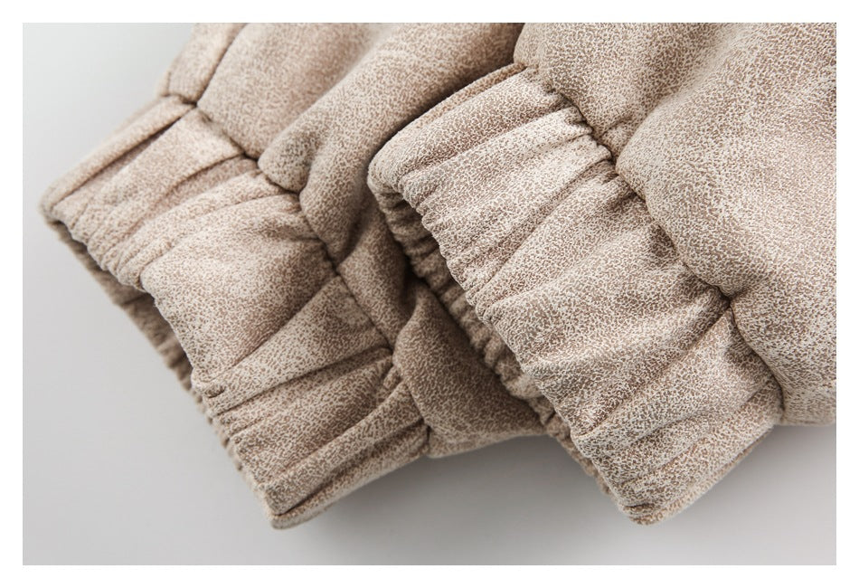 Close-up of gathered elastic garment cuffs in pale beige mottled fabric.