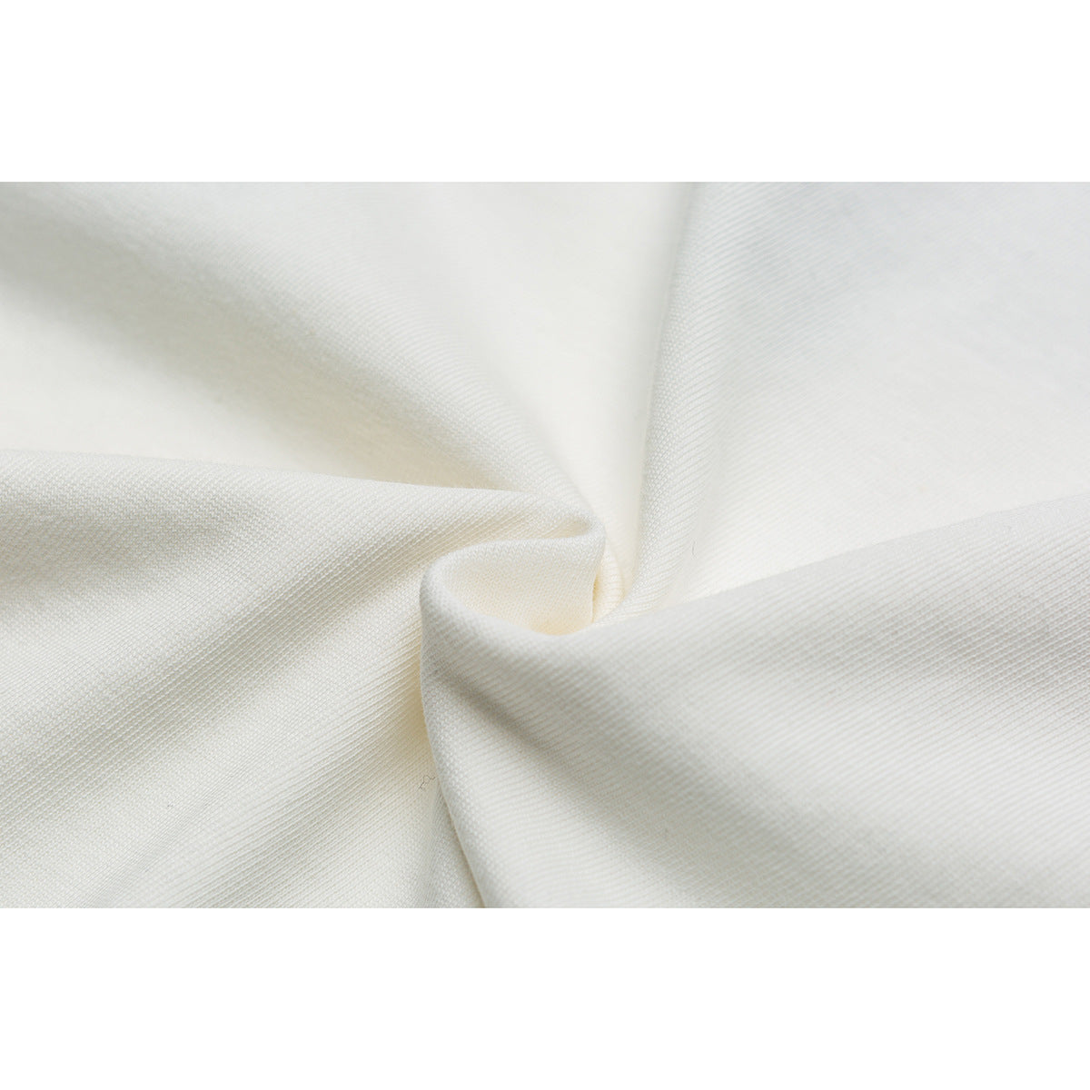 Close-up of ivory fabric gathered into soft folds.
