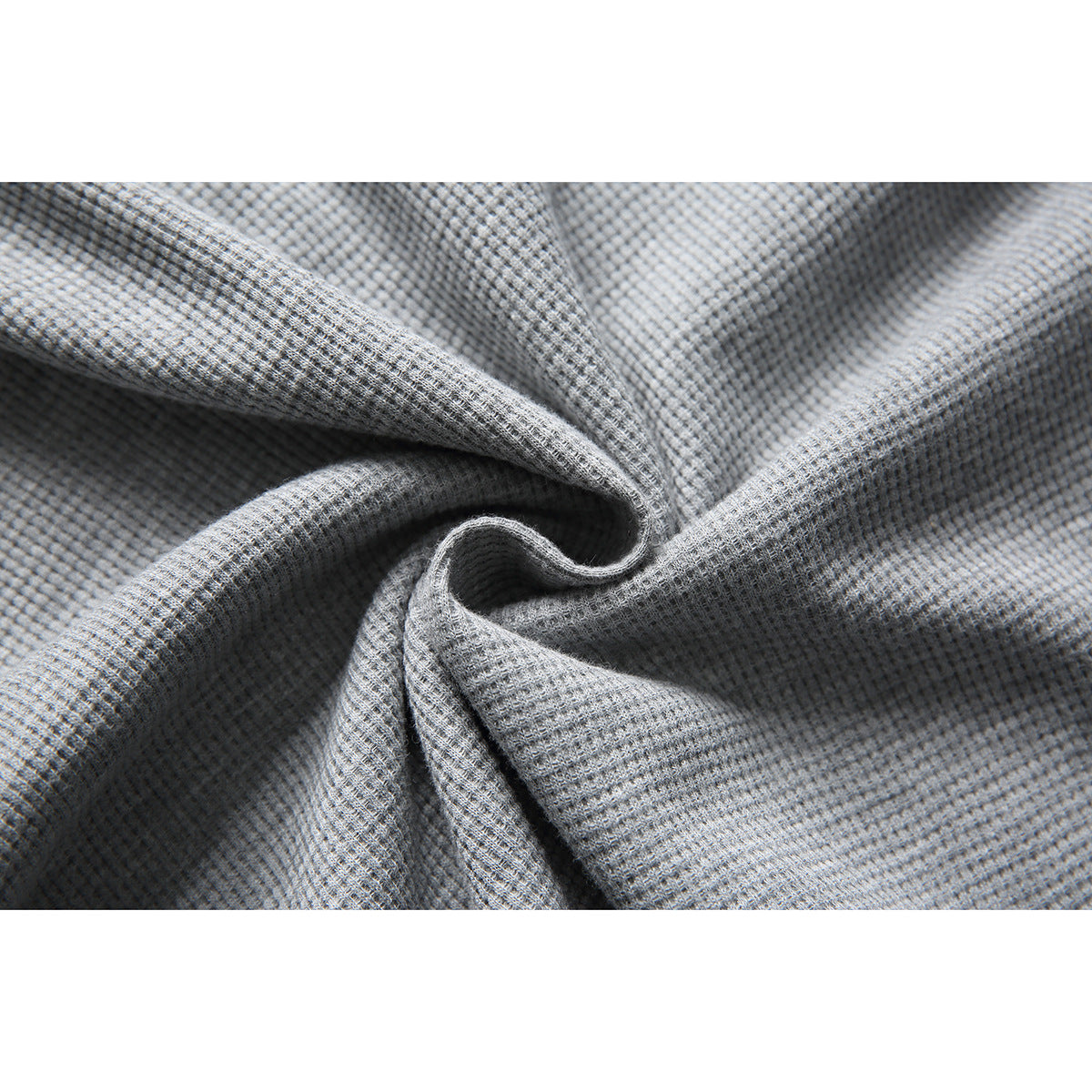 Close-up of gray textured shirt fabric gathered into soft folds.