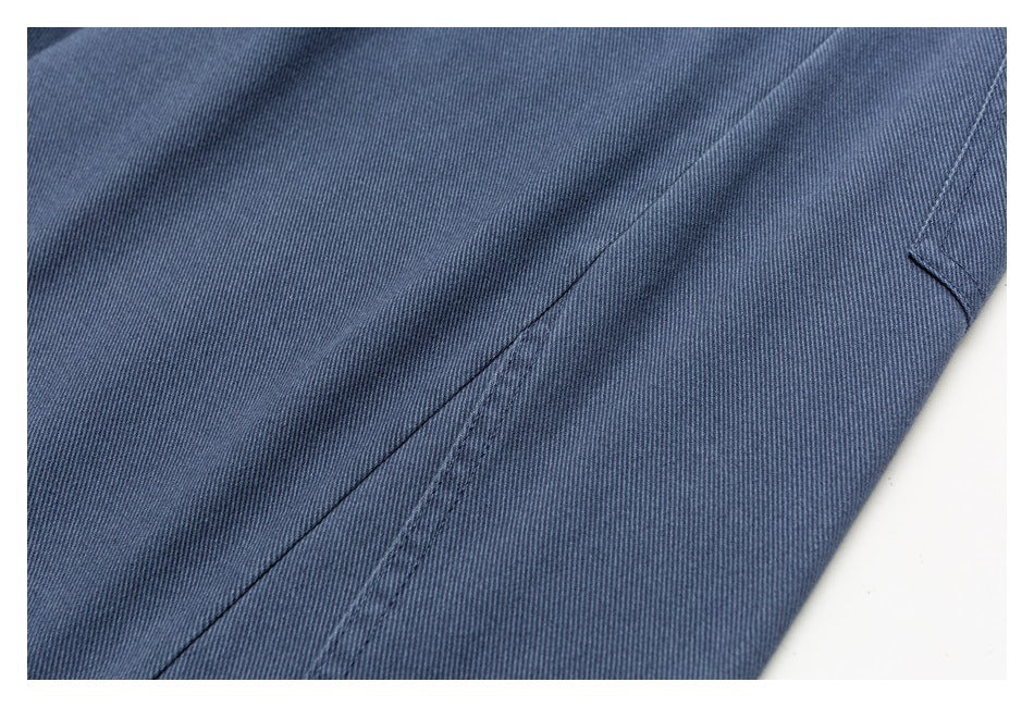 Close-up of blue pants fabric and stitching along a diagonal seam.
