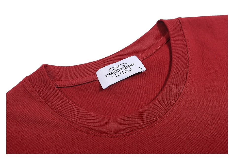Close-up of the red T-shirt’s ribbed crew neckline and sewn-in white label.