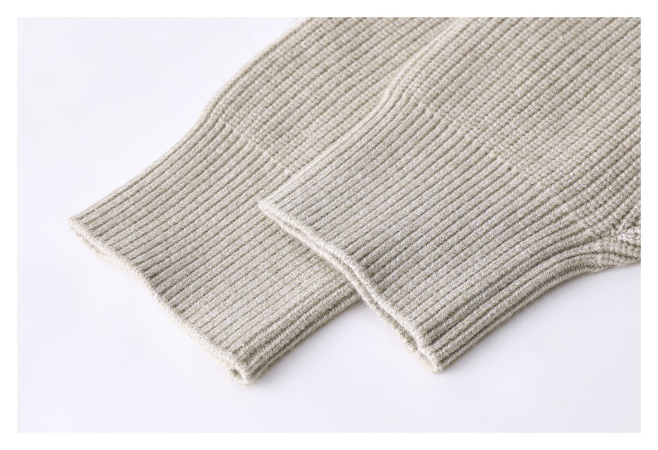 Close-up of the cream ribbed knit sweater's sleeve cuff and seam.