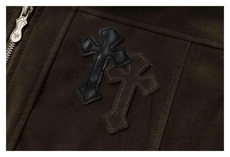 Close-up of black and brown cross-shaped appliqués stitched onto a dark brown jacket.