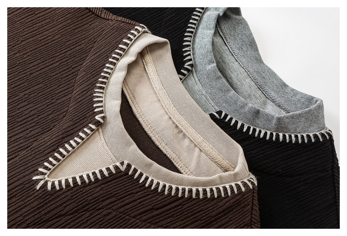 Close-up of brown, black, and gray ribbed tops showing contrast neckbands and cream blanket stitching.