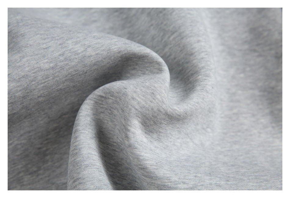 Close-up of light gray heathered fabric draped into soft folds.