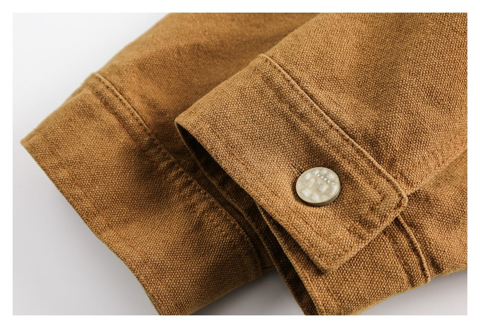 Close-up of a camel-brown sleeve cuff with a pale round button and visible stitching.